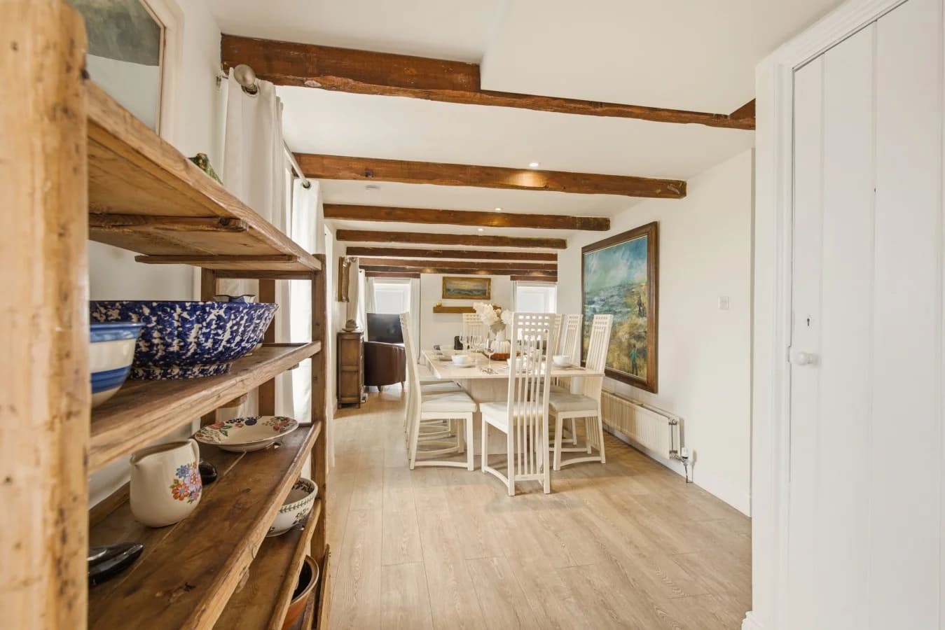 Dining area with exposed beams and oak flooring