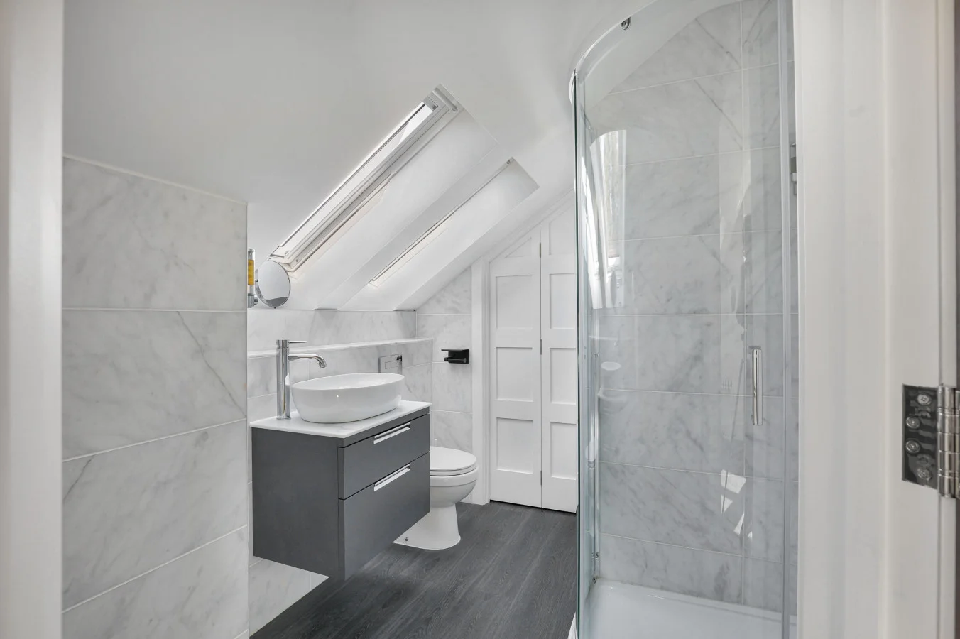 En-suite shower room with skylight, vanity unit and heated towel rail