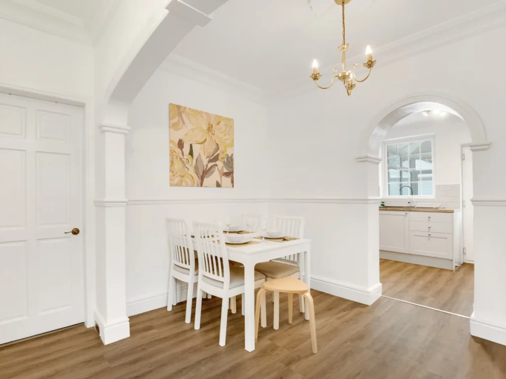 Bright dining space with table and chairs beside the open kitchen area