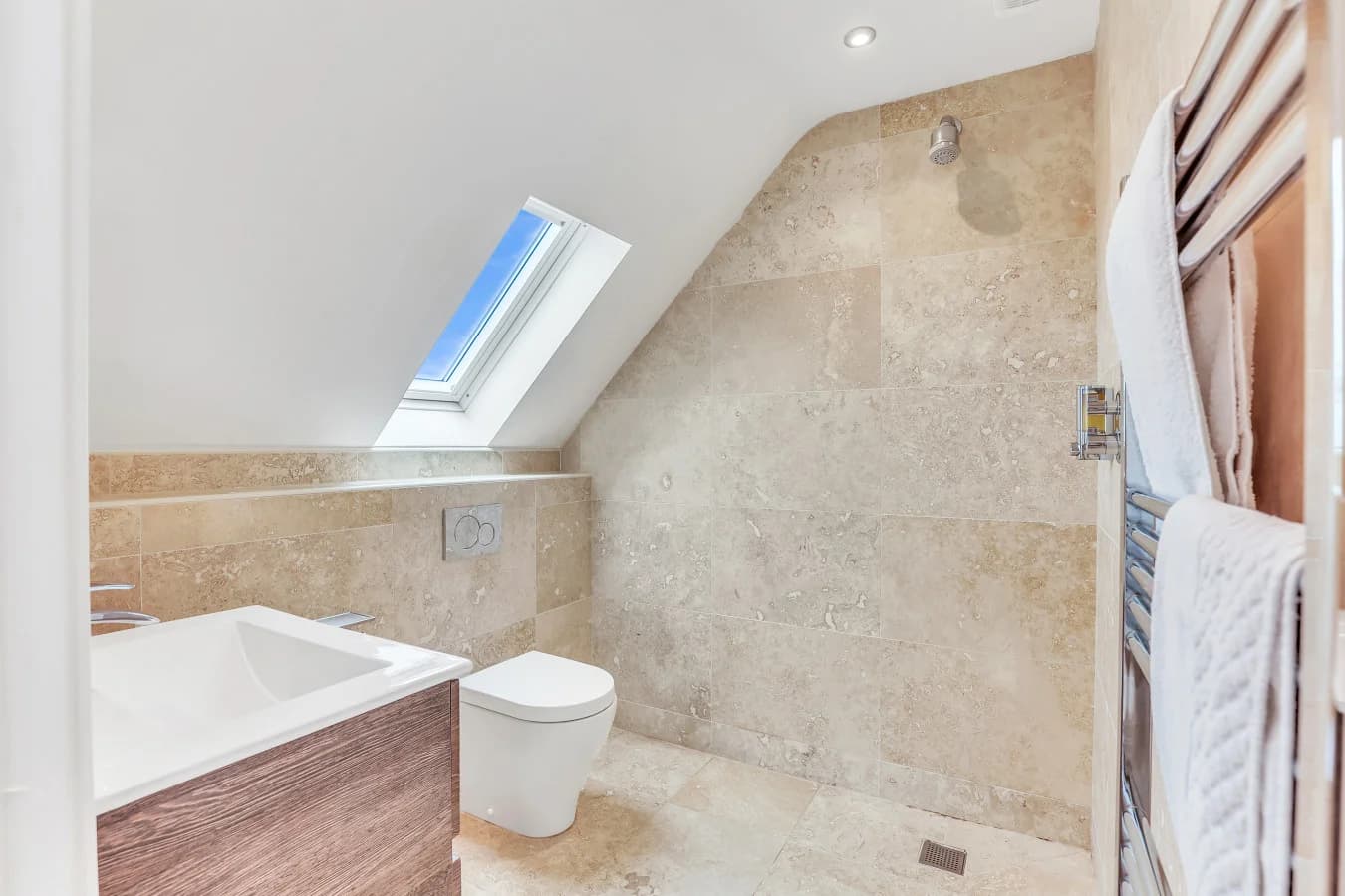 Ensuite bathroom with bath, skylight and stone-effect tiling