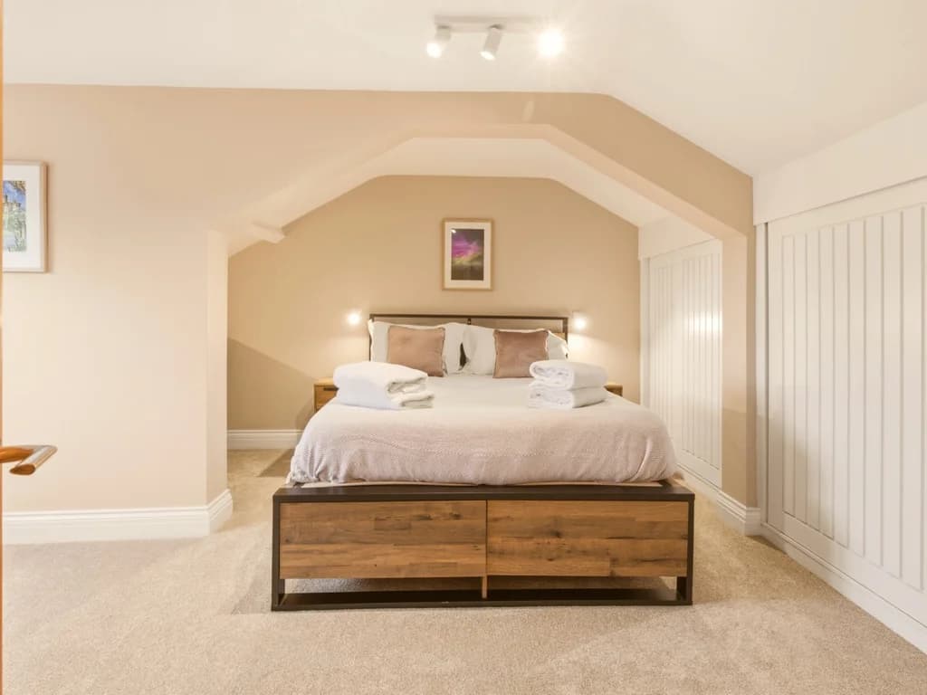 Generous top-floor king bedroom with built-in wardrobes and en-suite access.