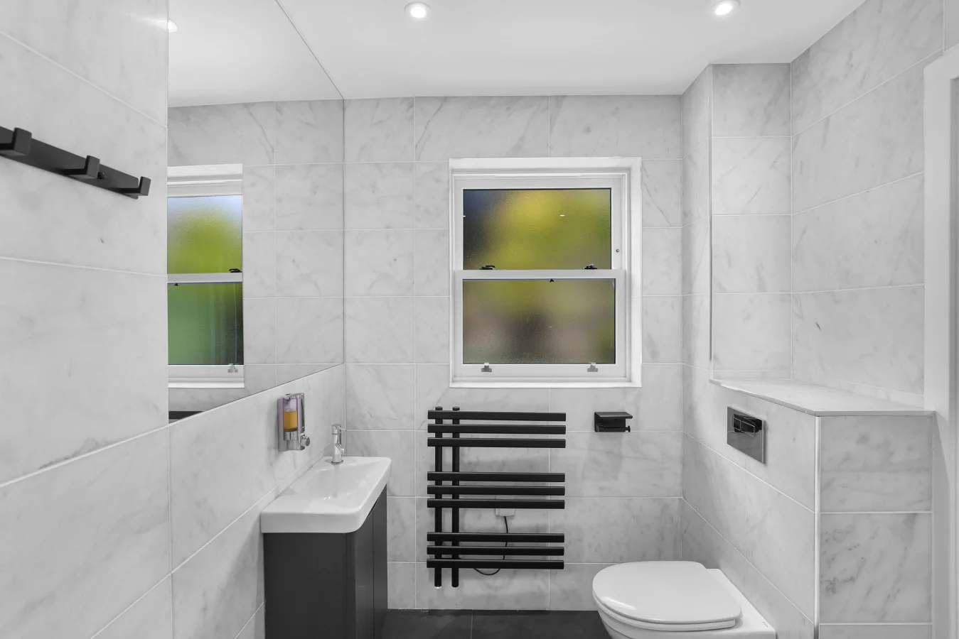 Family bathroom with black heated towel rail and vanity unit
