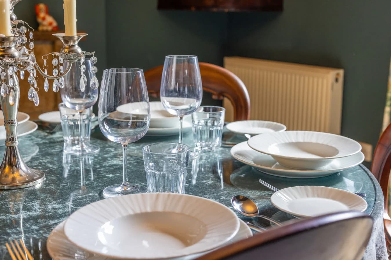 Marble-topped dining table with crystal glassware and place settings