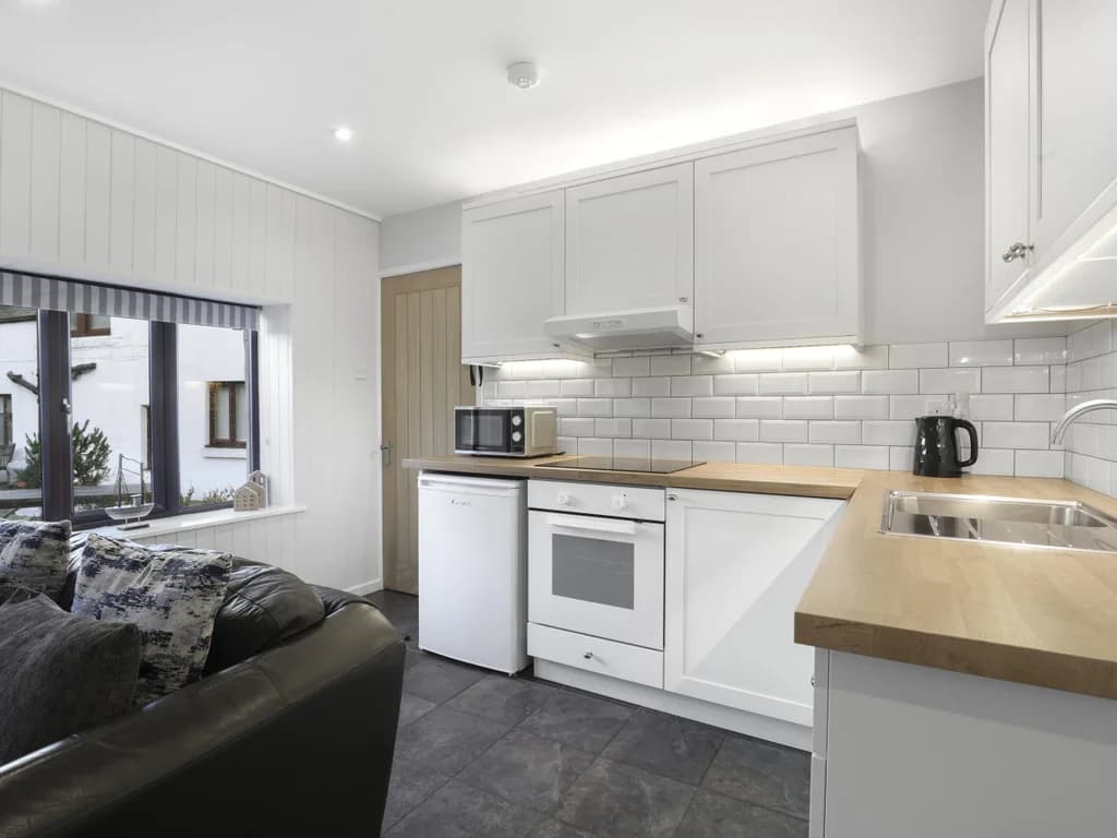 Modern fitted kitchen with timber worktops and tiled splashback
