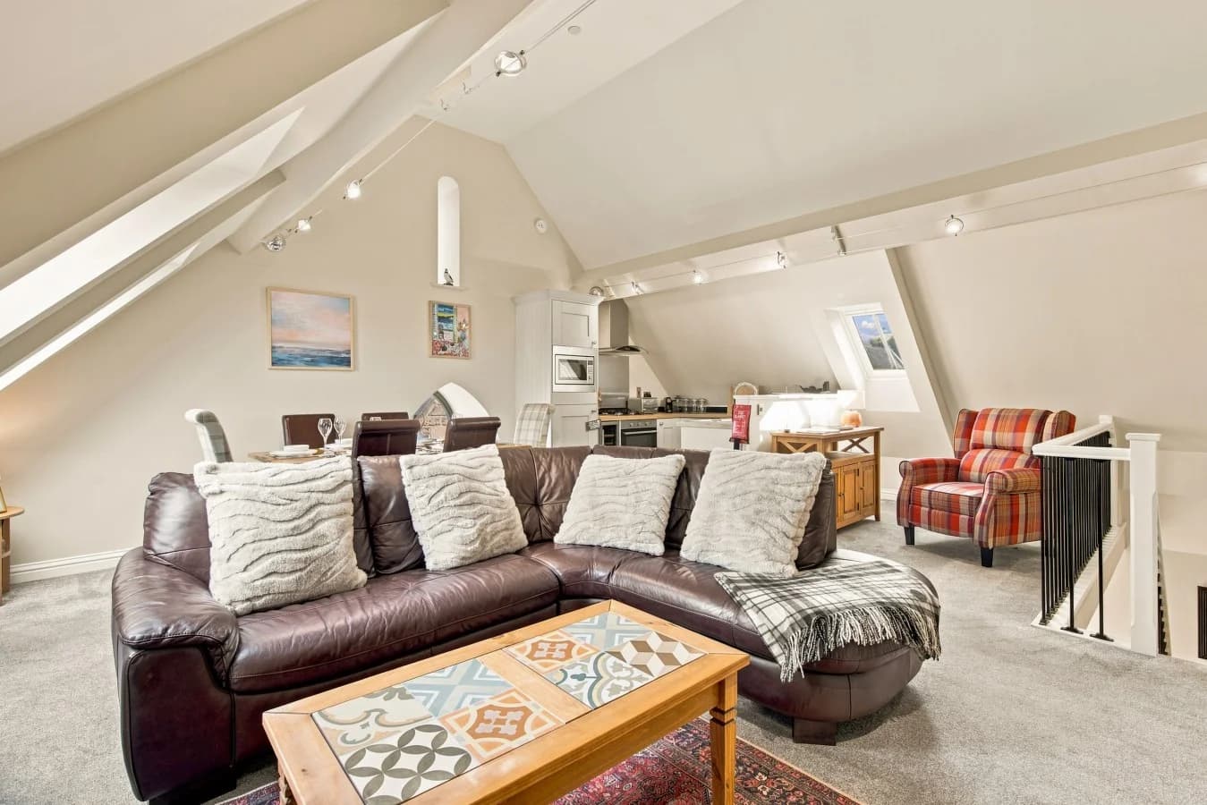 Spacious vaulted lounge with leather sofas and open-plan living space.