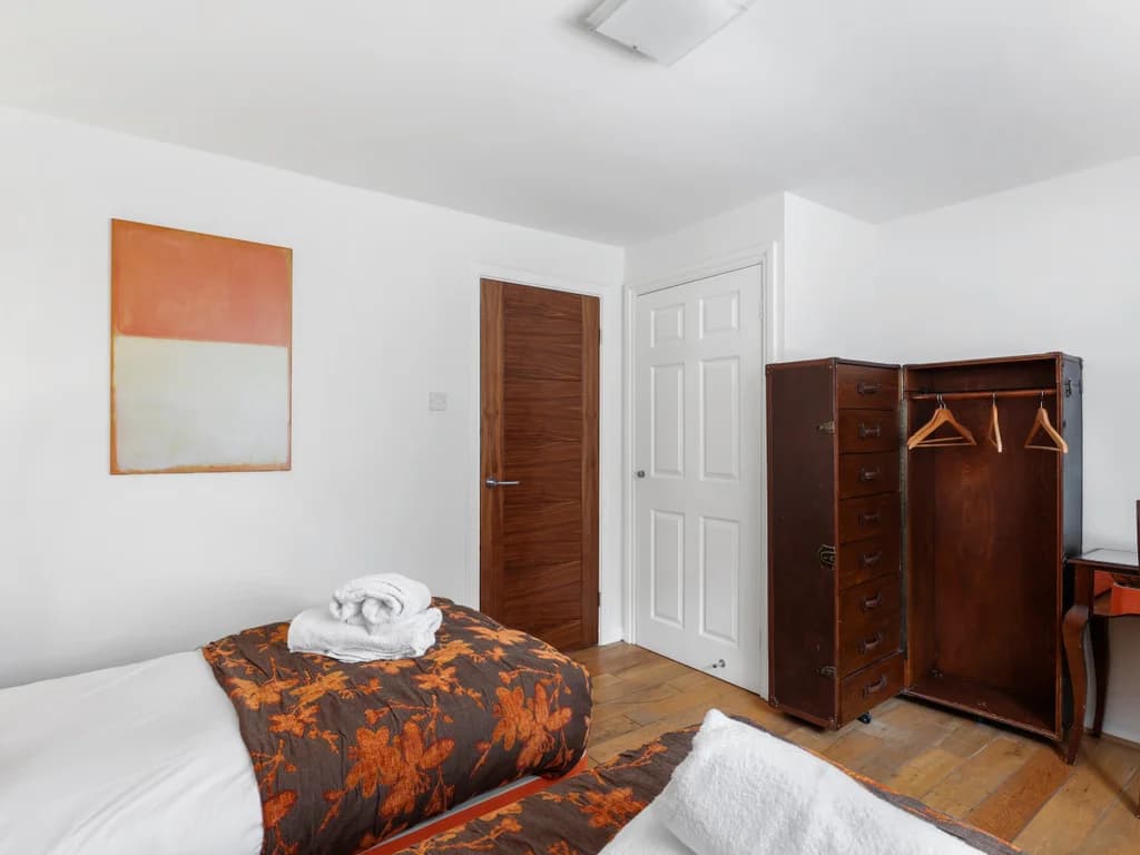 Twin bedroom with freestanding wardrobe and dressing table