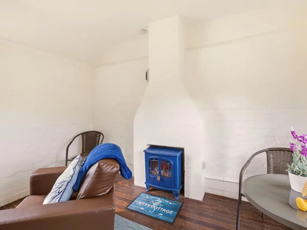 Jetty Cottage interior with seating, dining table and wood-burning stove