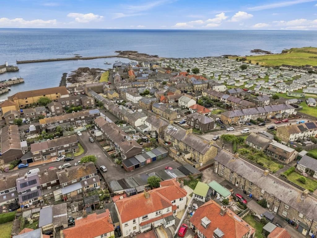 Aerial view of Seahouses harbour, coastline and surrounding village.