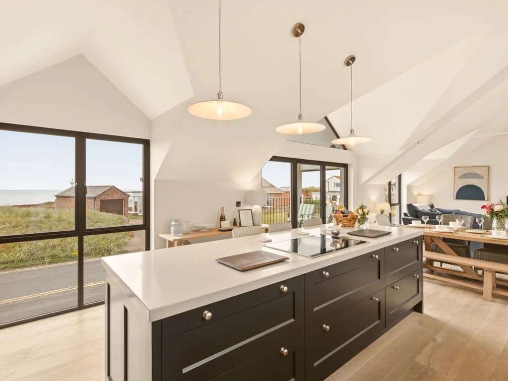 Spacious kitchen island with panoramic windows and open-plan living beyond