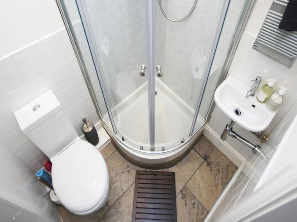 Compact shower room with shower, WC and wash basin.