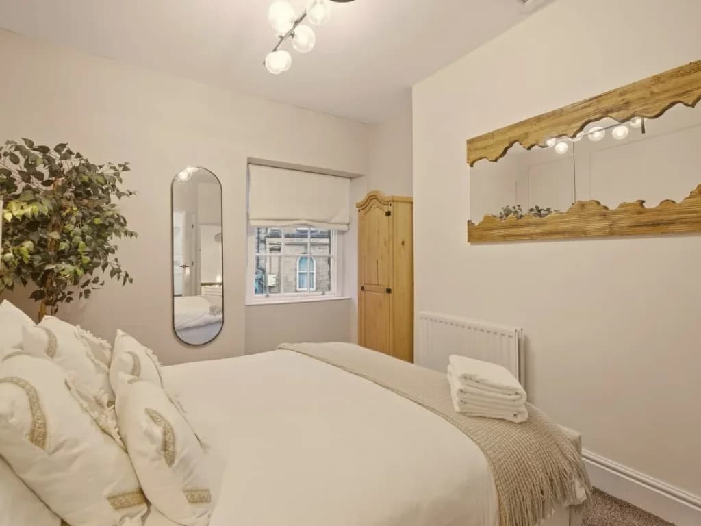 Another view of the king bedroom with ornate mirror and natural light.