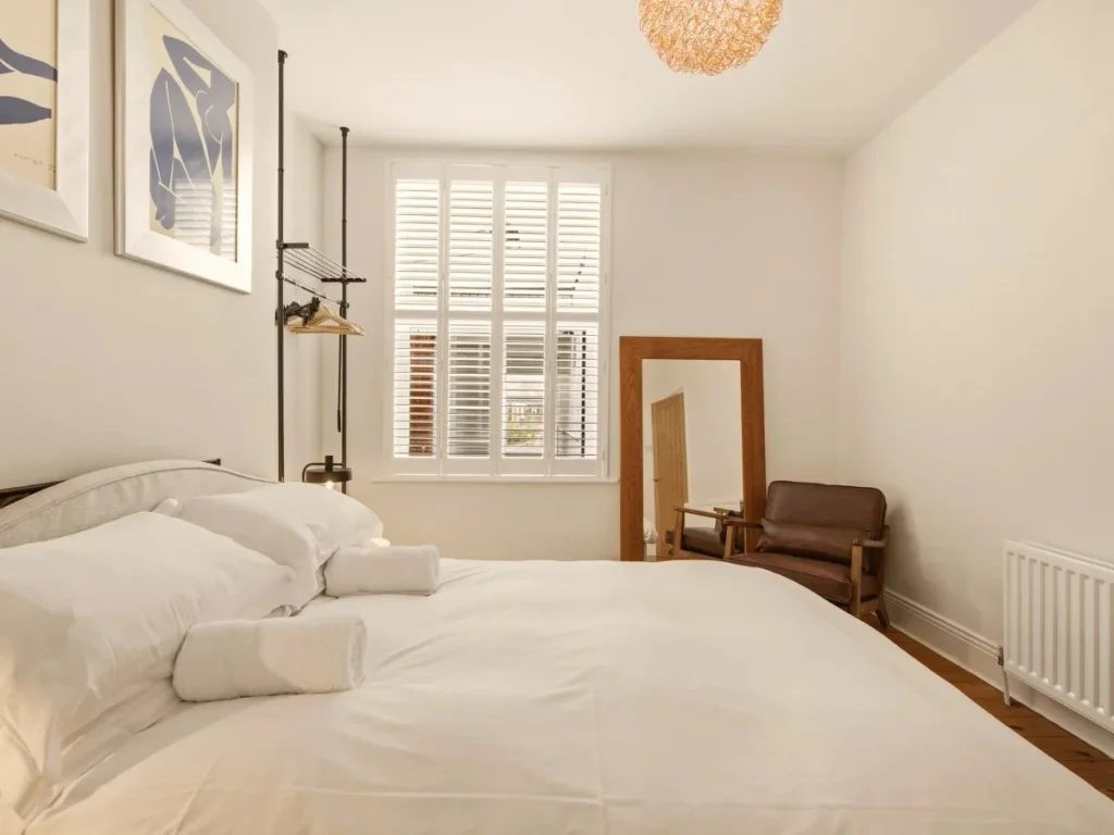 King-size bedroom with hanging rail, full-length mirror and wooden chair