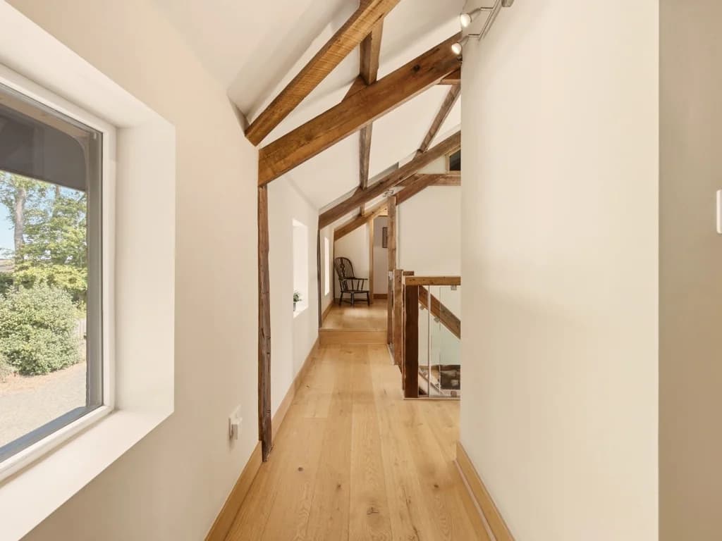 Timber-beamed first-floor walkway with views across the grounds