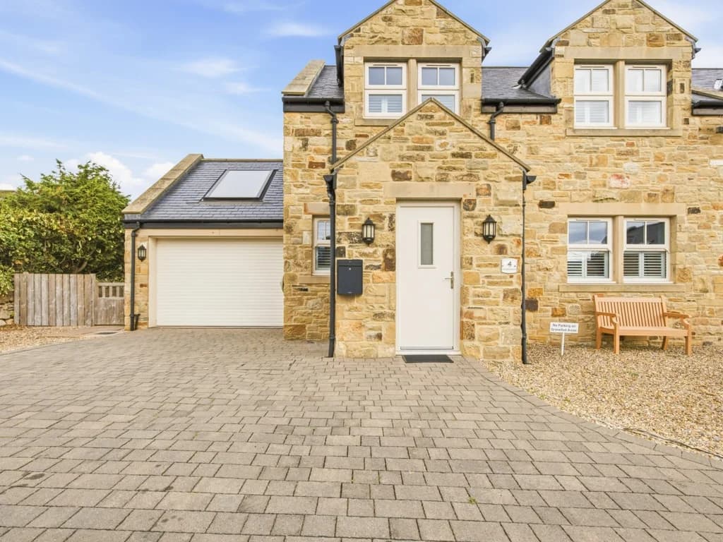 Stone-built exterior with spacious private driveway and garage