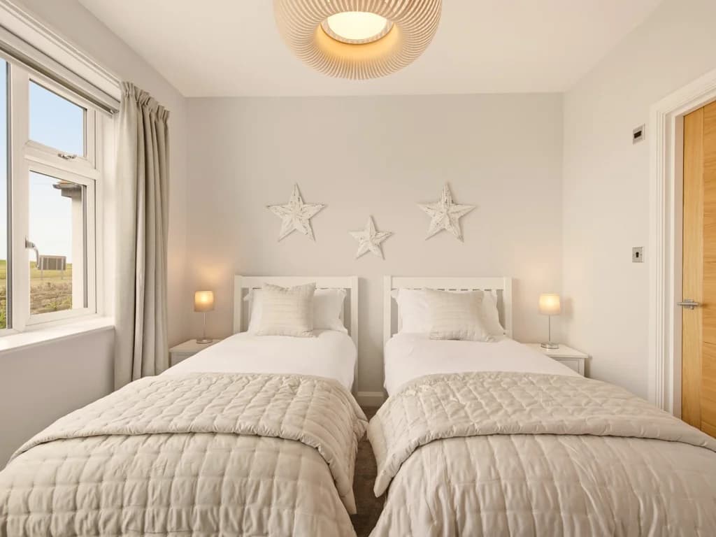 Spacious twin bedroom with charming coastal touches and plenty of natural light