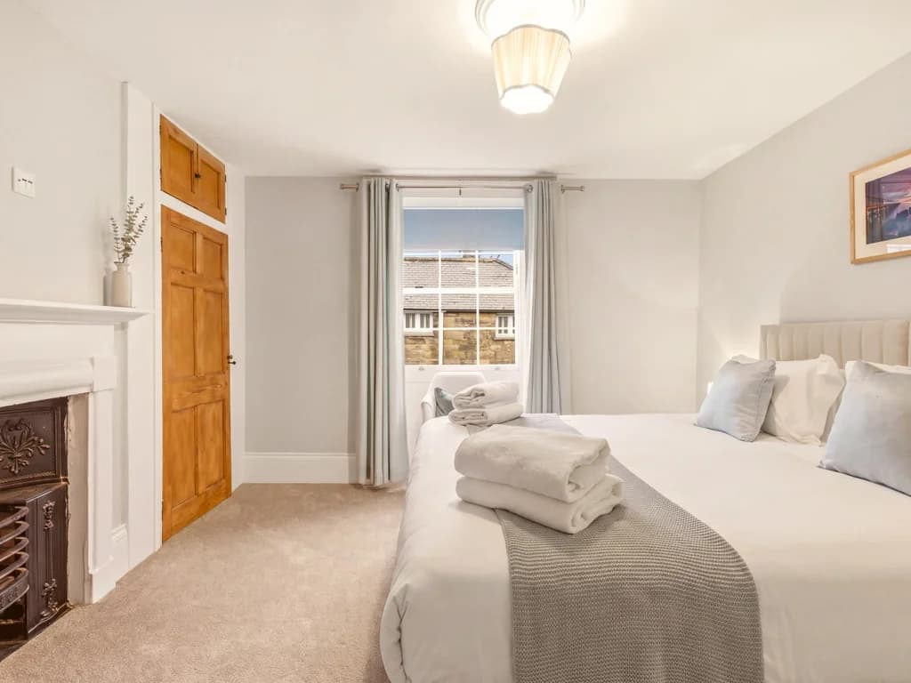 Bright King Zip bedroom with decorative fireplace and period charm.