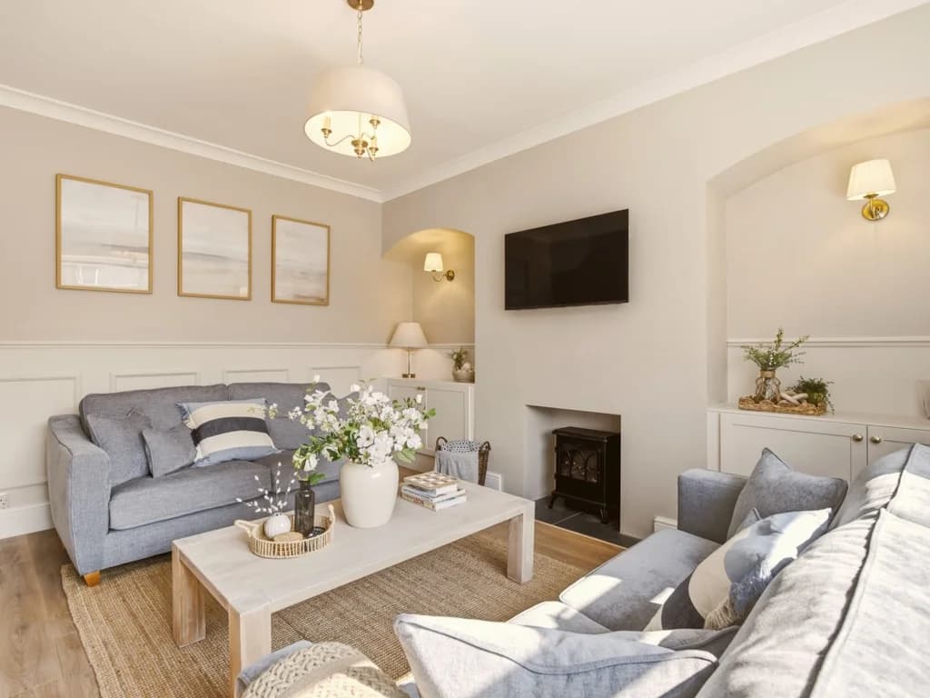 Spacious lounge with comfortable seating and wall-mounted Smart TV
