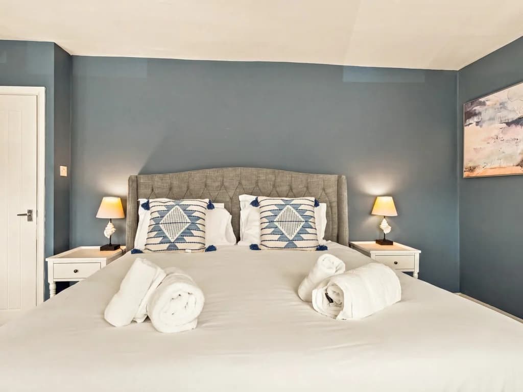 King bedroom with upholstered headboard and matching bedside tables.