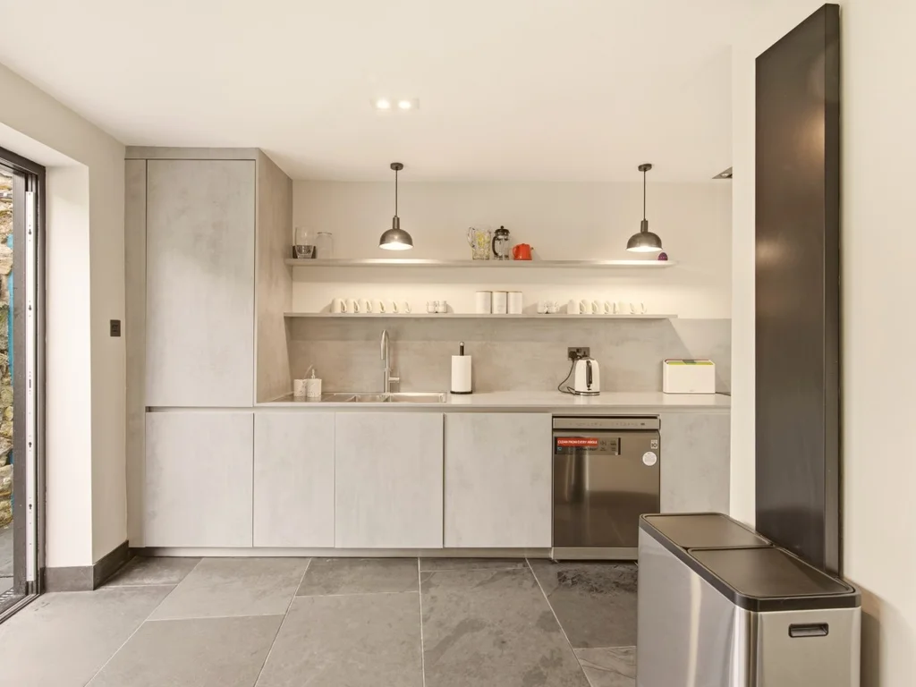 Contemporary fitted kitchen with garden access and integrated appliances.