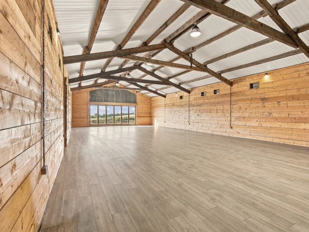 Expansive event space with exposed beams and wide countryside outlook