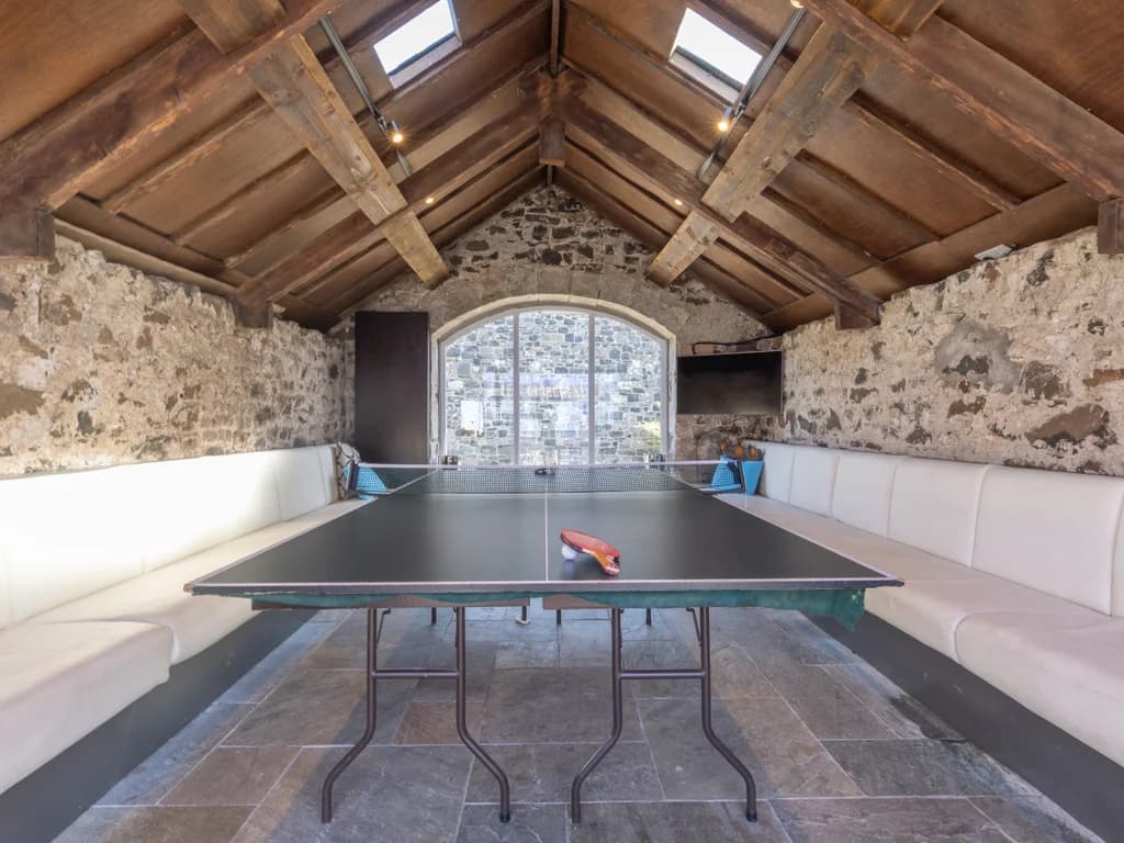 Table tennis room with vaulted timber ceiling and stone walls