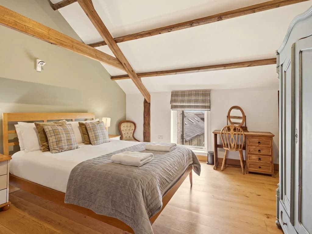 King-size bedroom with exposed beams, wardrobe and dressing table