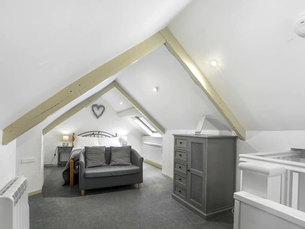 Upper-floor retreat with skylight, sofa seating and character beams