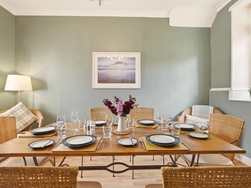 Spacious dining room with wicker chairs and table set for memorable family meals