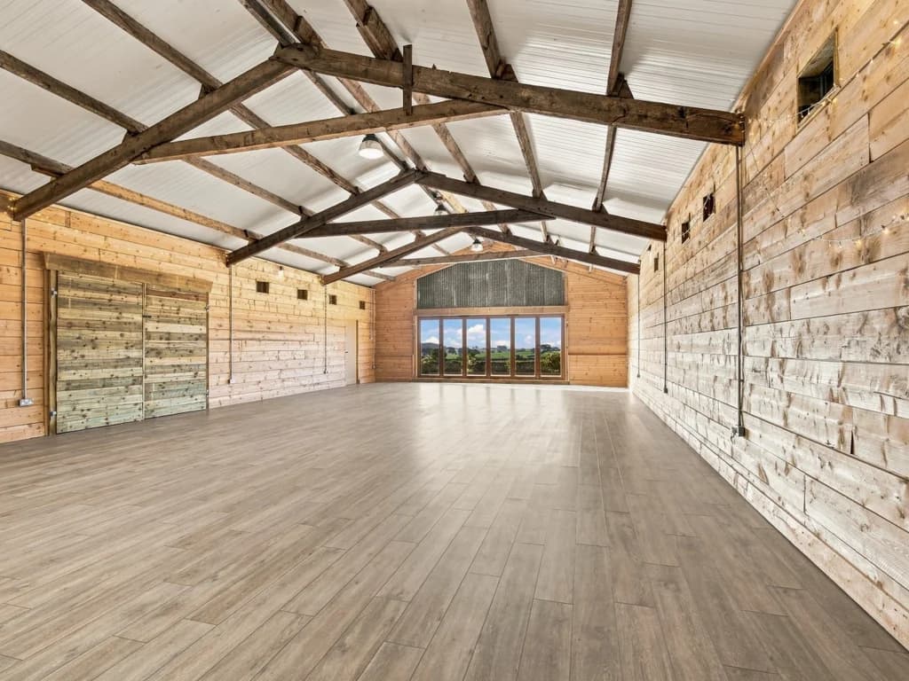 Spacious event area with exposed timber beams and countryside views