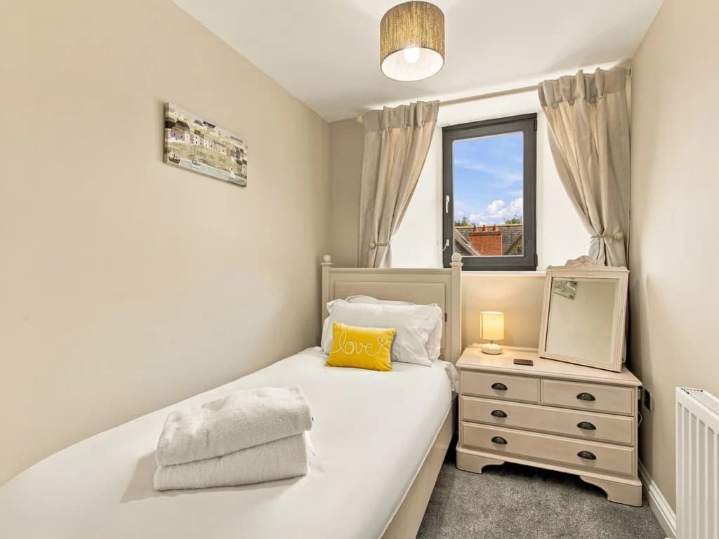 Single bedroom with chest of drawers and rooftop views.