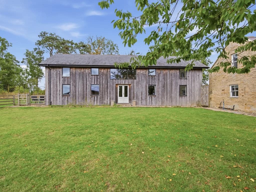 Timber-clad exterior of Drum Barn overlooking the open lawn