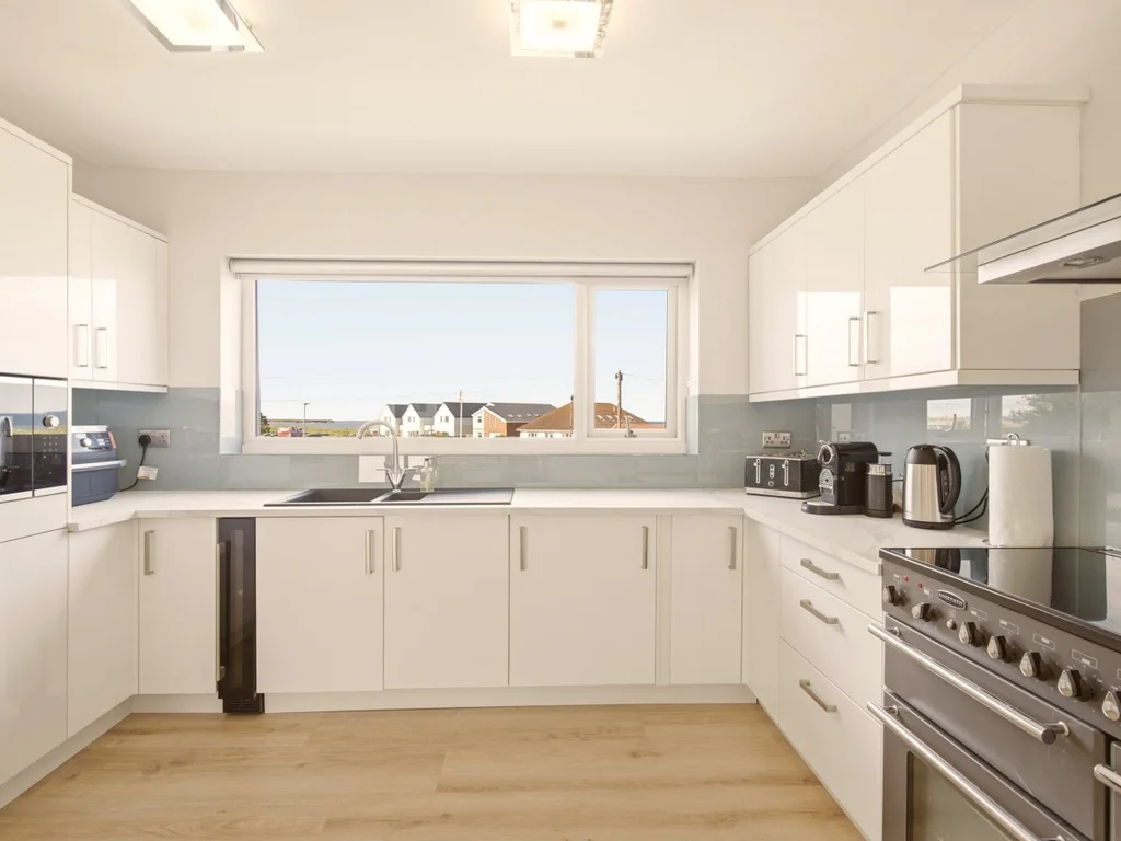 Bright contemporary kitchen with sleek finishes and views towards the coast