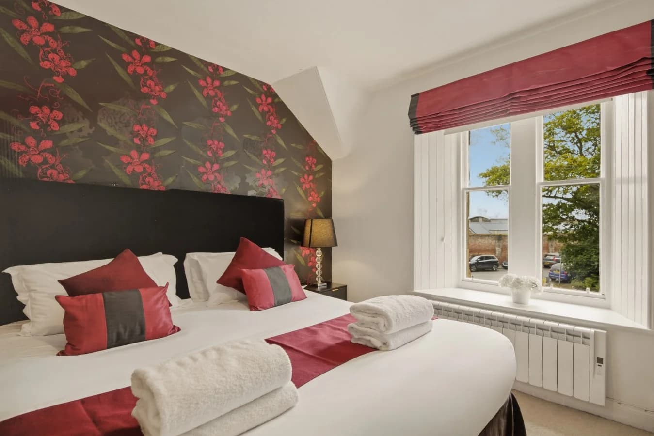 Super king bedroom with feature fireplace and wall-mounted TV