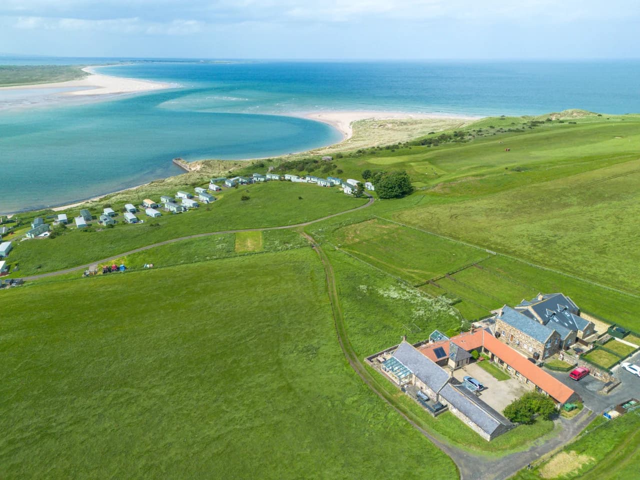 Aerial view of Budle Newton Cottage beside the coastline