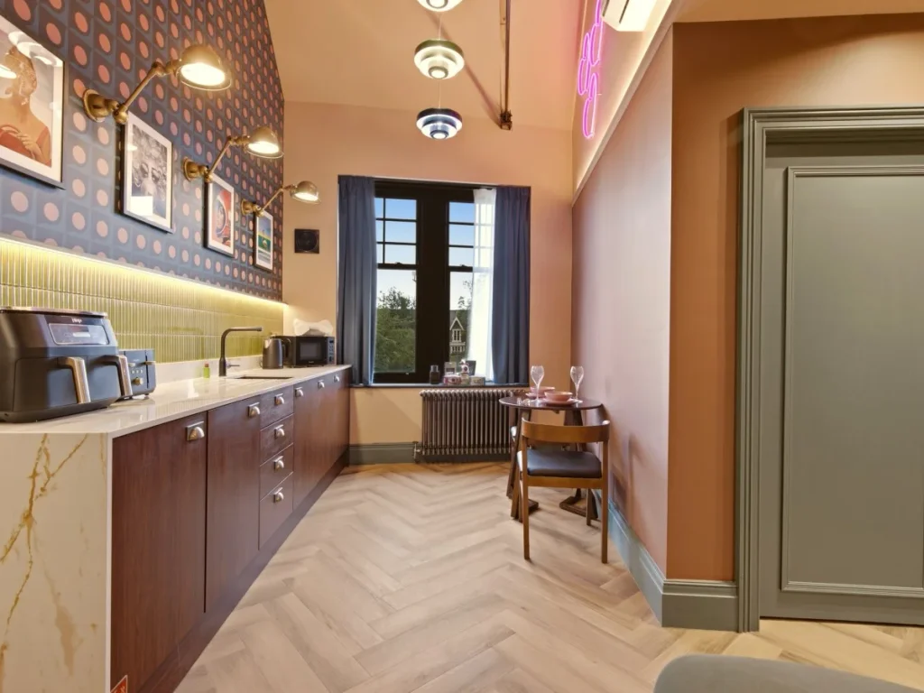 Kitchenette and dining space with tall window and patterned feature wall