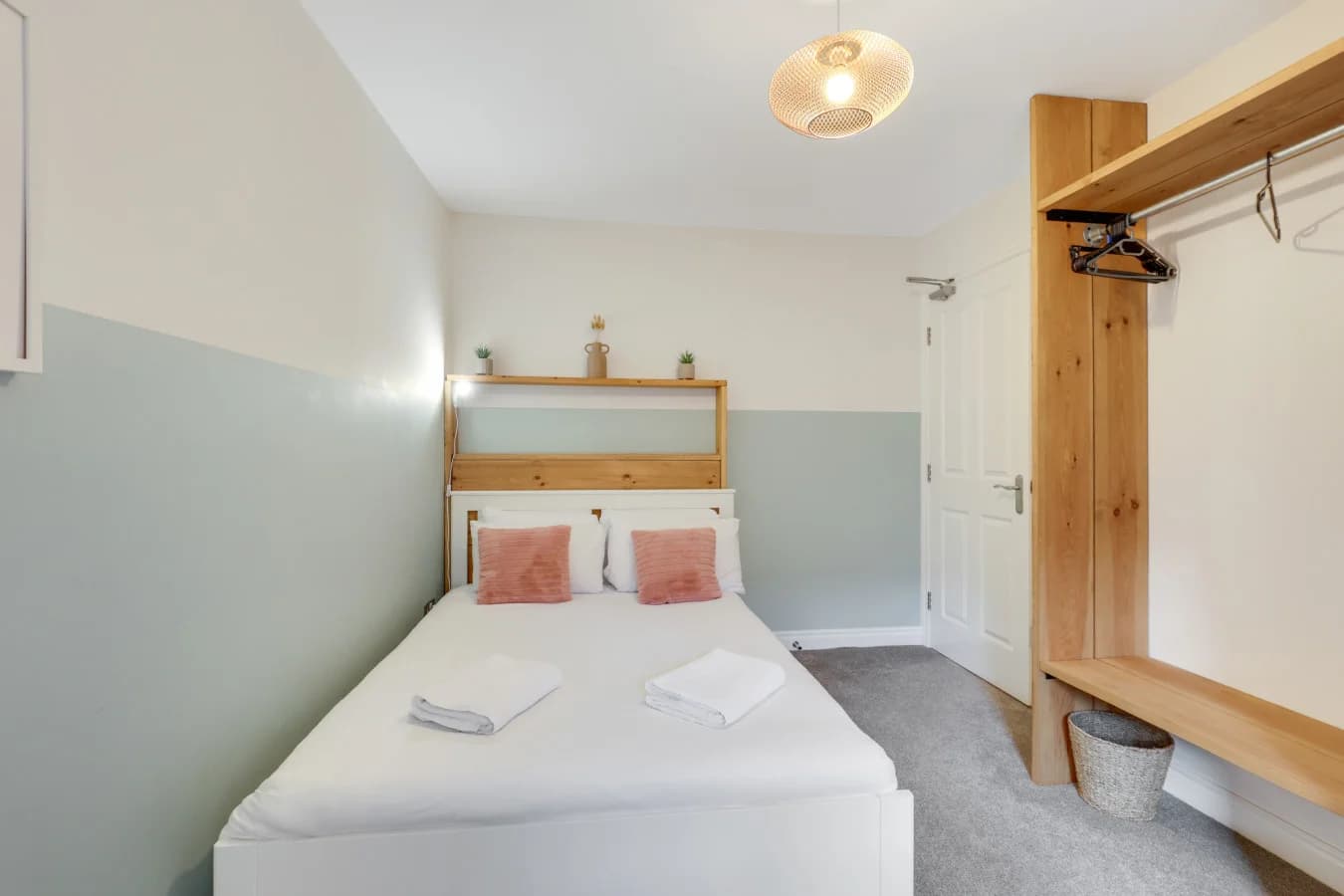 Comfortable bedroom featuring bespoke oak storage and warm neutral tones