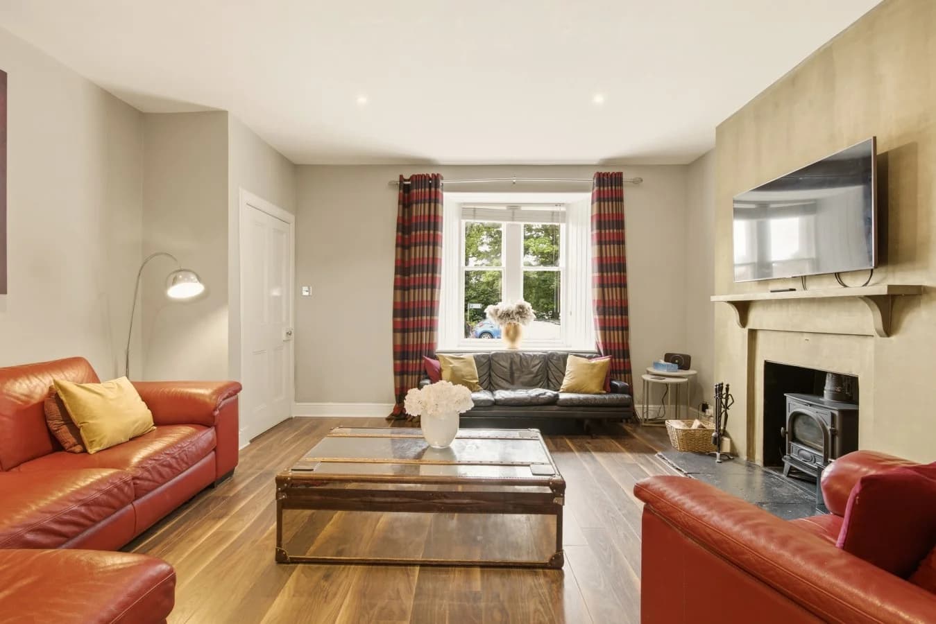 Living room with wood-burning stove, TV and oak flooring