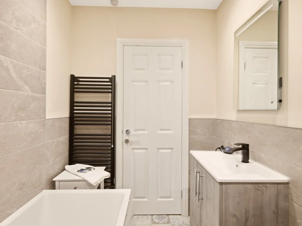 Modern family bathroom with vanity unit, heated towel rail and mirror.