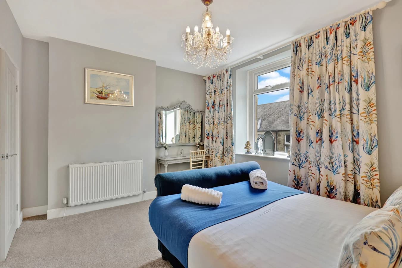 Elegant double bedroom with soft neutral décor and crystal lighting