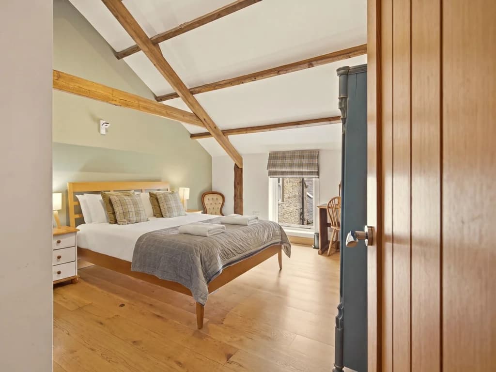 Spacious bedroom with king-size bed and exposed timber beams