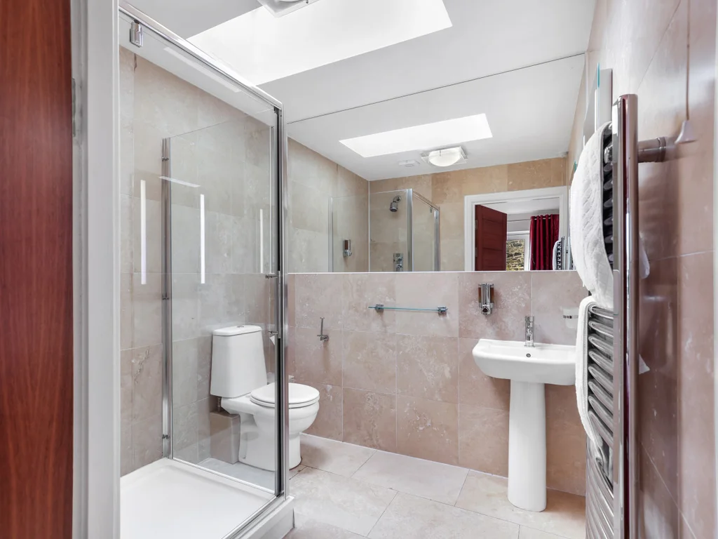 Ensuite shower room with walk-in shower and neutral stone tiles