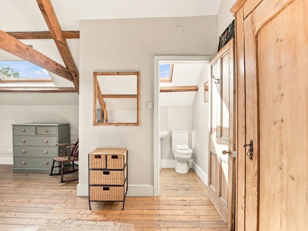 Bedroom storage area with timber beams and adjoining en-suite