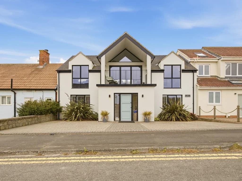 Contemporary front elevation with private driveway and first-floor balcony
