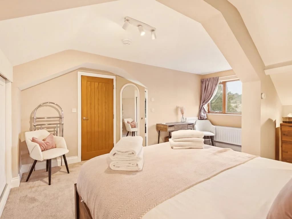 Spacious top-floor king bedroom with en-suite and dressing area.