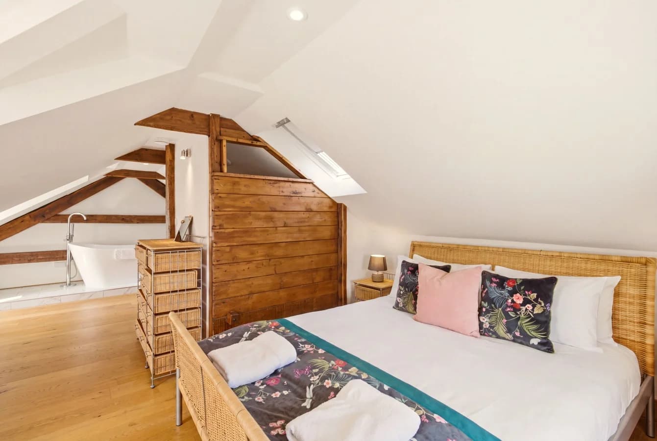 Hayloft bedroom with queen-size bed and freestanding bath nearby