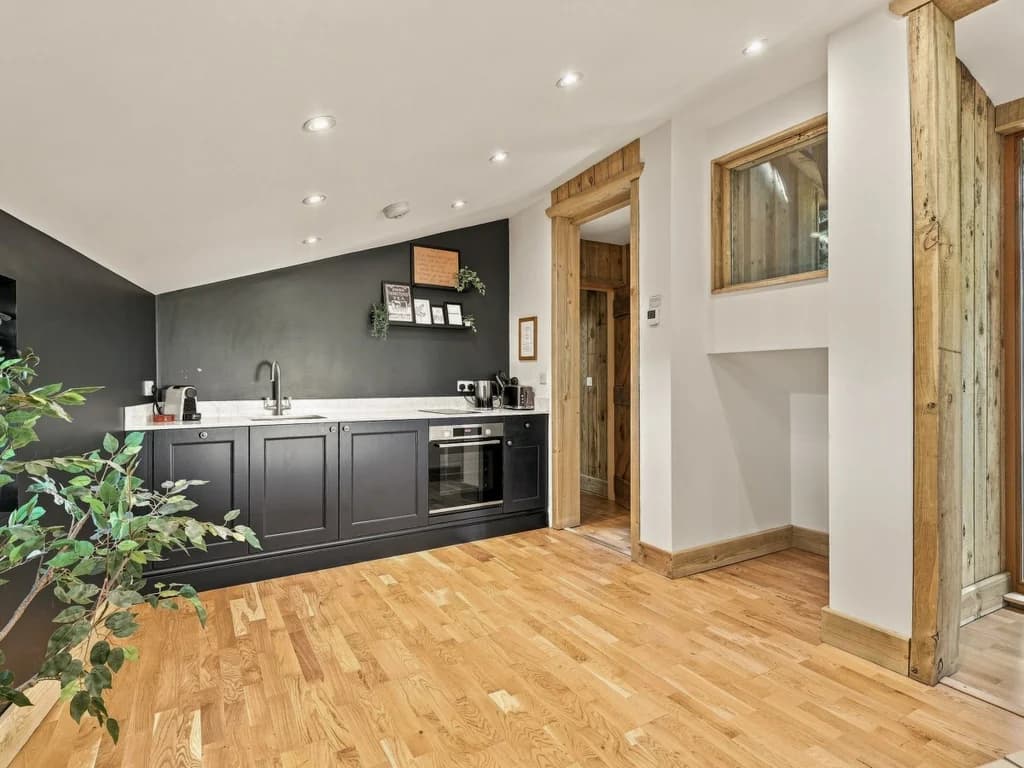 Well-equipped kitchen with dark cabinetry and wooden flooring