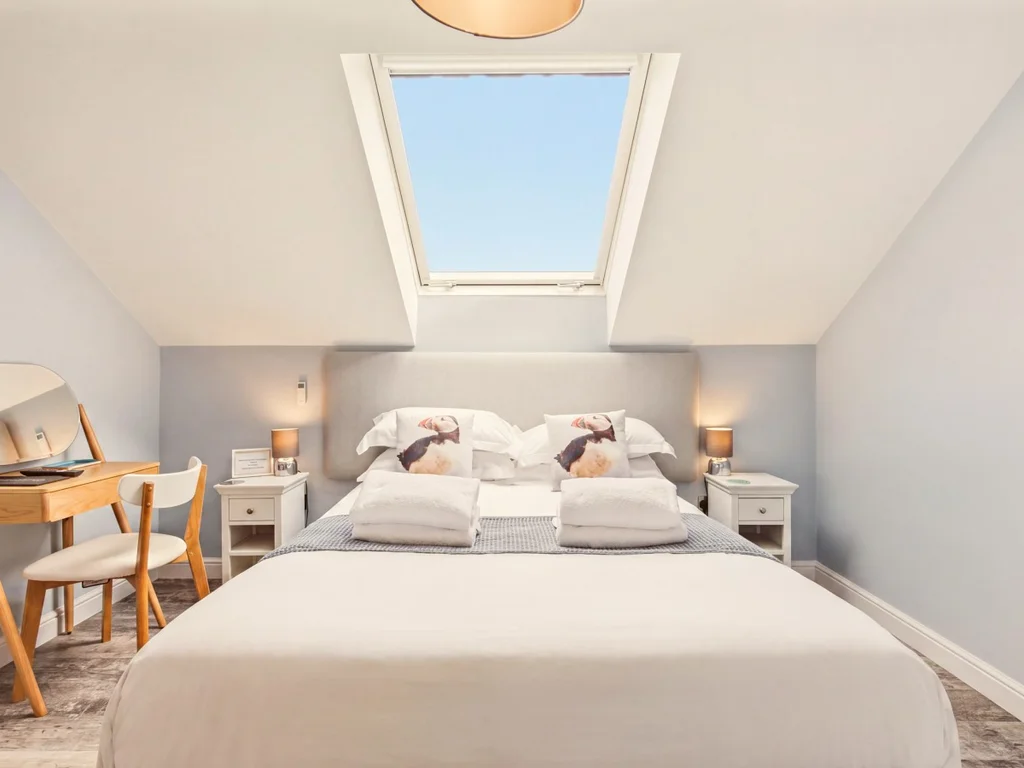 King-size bedroom beneath a skylight with dressing table and storage