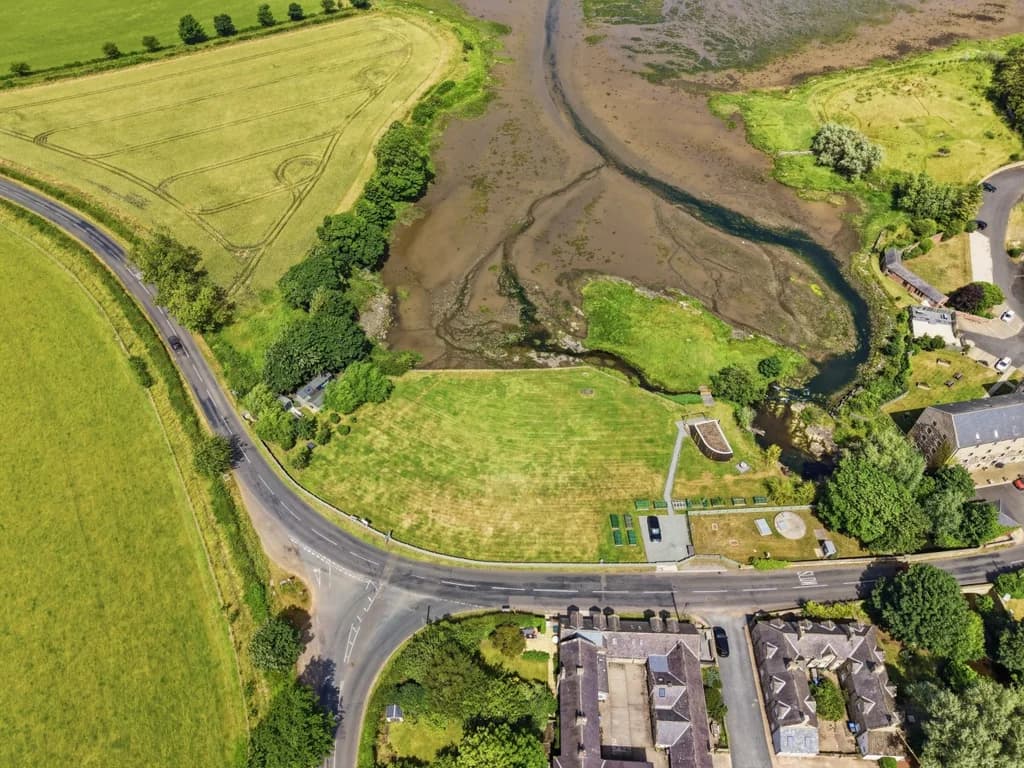 Aerial view of Waren Mill with Budle Bay and surrounding countryside beyond
