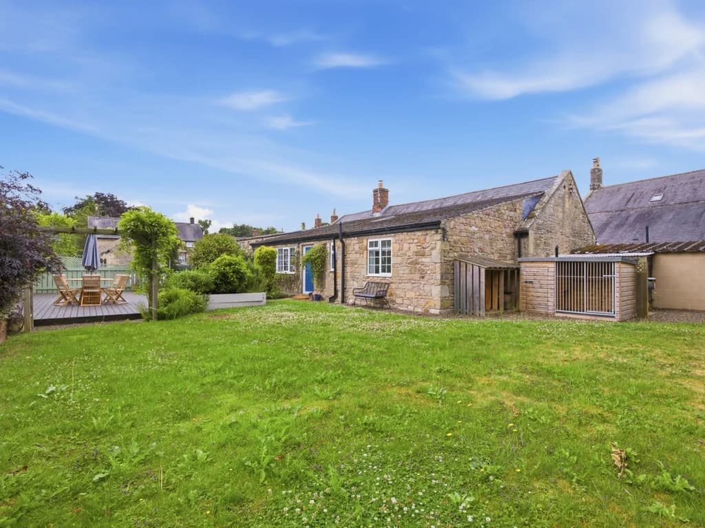 Spacious enclosed garden with lawn, decked patio and outdoor dining area