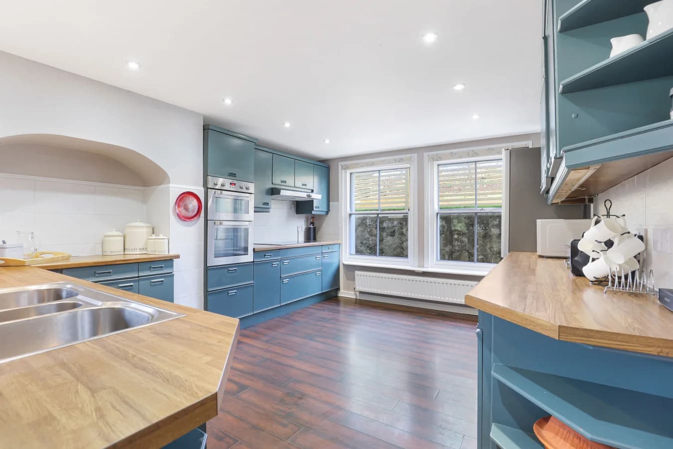 Large country kitchen with blue cabinetry and wood worktops